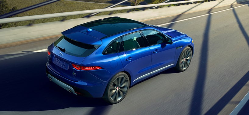 Blue Jaguar F-Pace Driving Across A Bridge